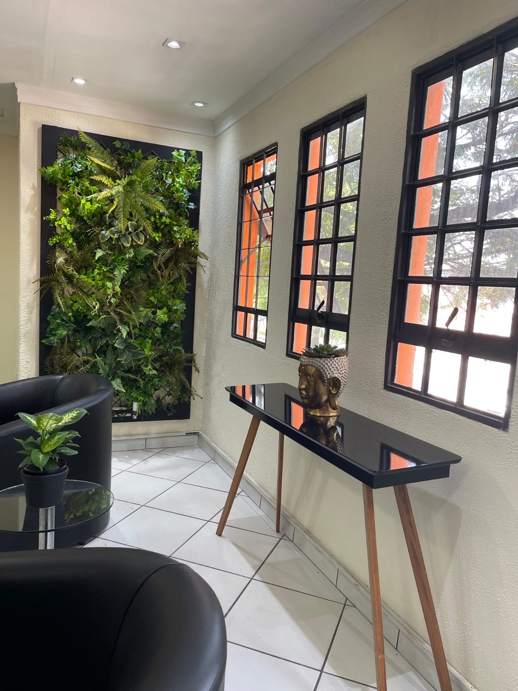 Recepção da World Quality com jardim vertical e poltronas
